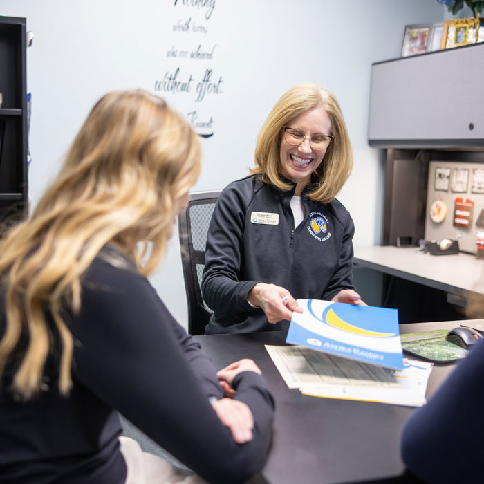 Female College Advisor meets with female student in office