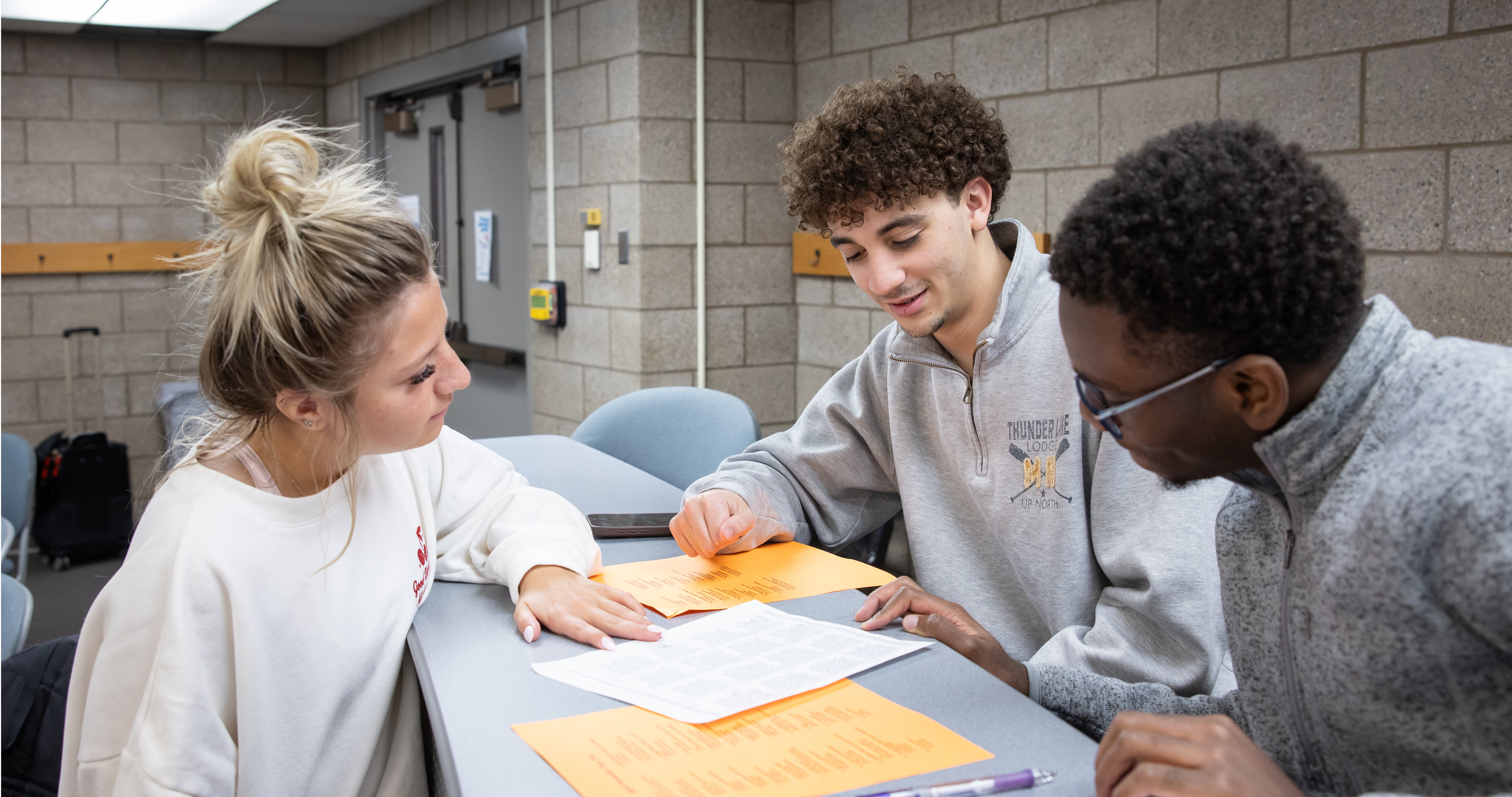 One female two male students studying together