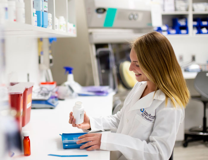 Pharmacy student preparing medication in a lab