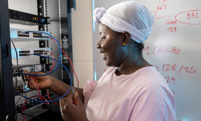 Student configuring network cables in an IT lab server rack