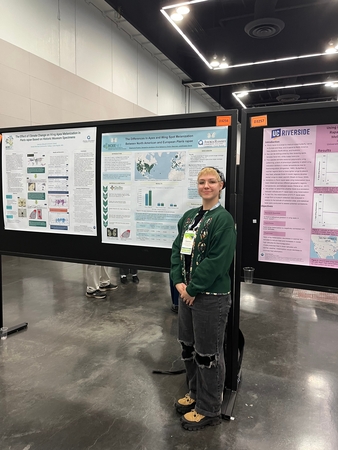 Individual standing in front of poster in civic center environment.